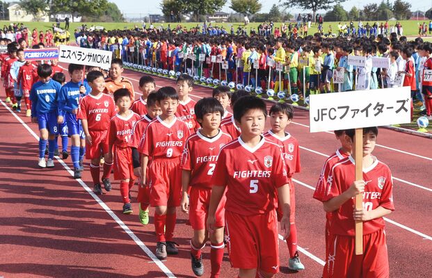 色とりどりのユニホーム姿で堂々と入場行進する選手たち＝１４日午前８時４０分、真岡ハイトラ運動公園陸上競技場