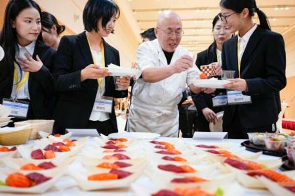 　ＪＥＴプログラムの壮行会で寿司を手にする参加者ら＝１１日、北京の日本大使館（共同）