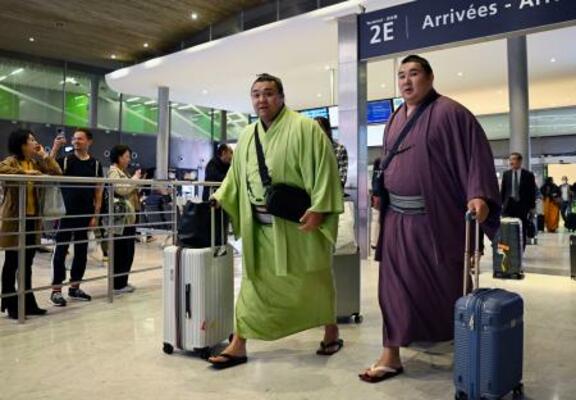 大相撲パリ公演に向け、フランスのシャルル・ドゴール空港に到着した大関霧島(左)ら=9日、パリ近郊(共同)