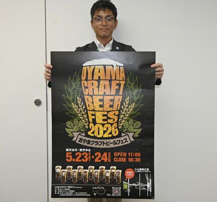 ビールフェスのポスターを持つノッツィの担当者